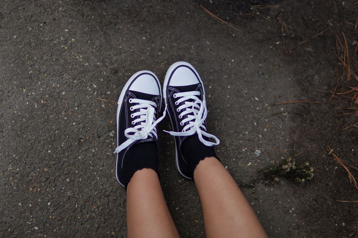 Casual black sneakers on outdoor pavement