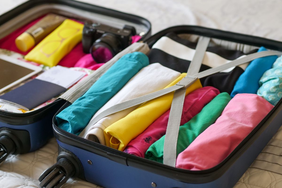 Blue luggage with folded clothes laid flat