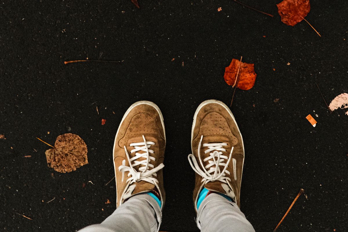 Sneakers walking through fallen autumn leaves