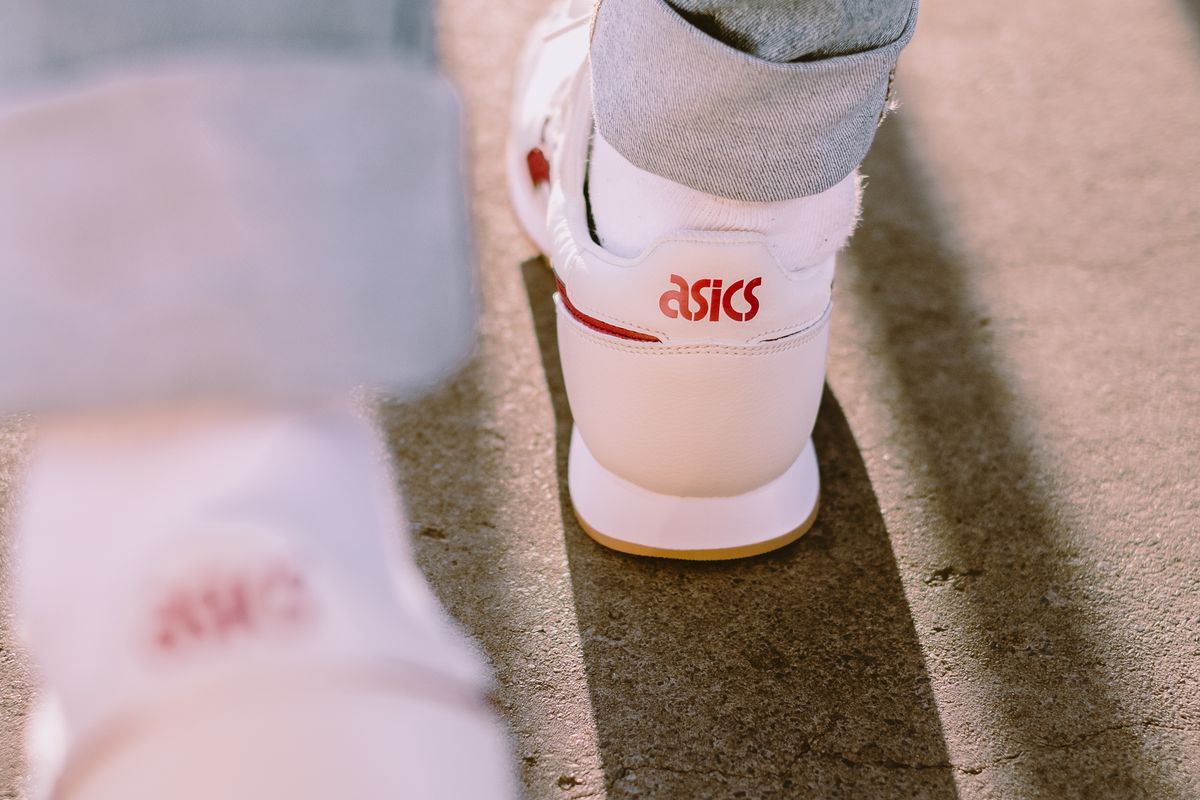Close view of white running shoes worn on pavement